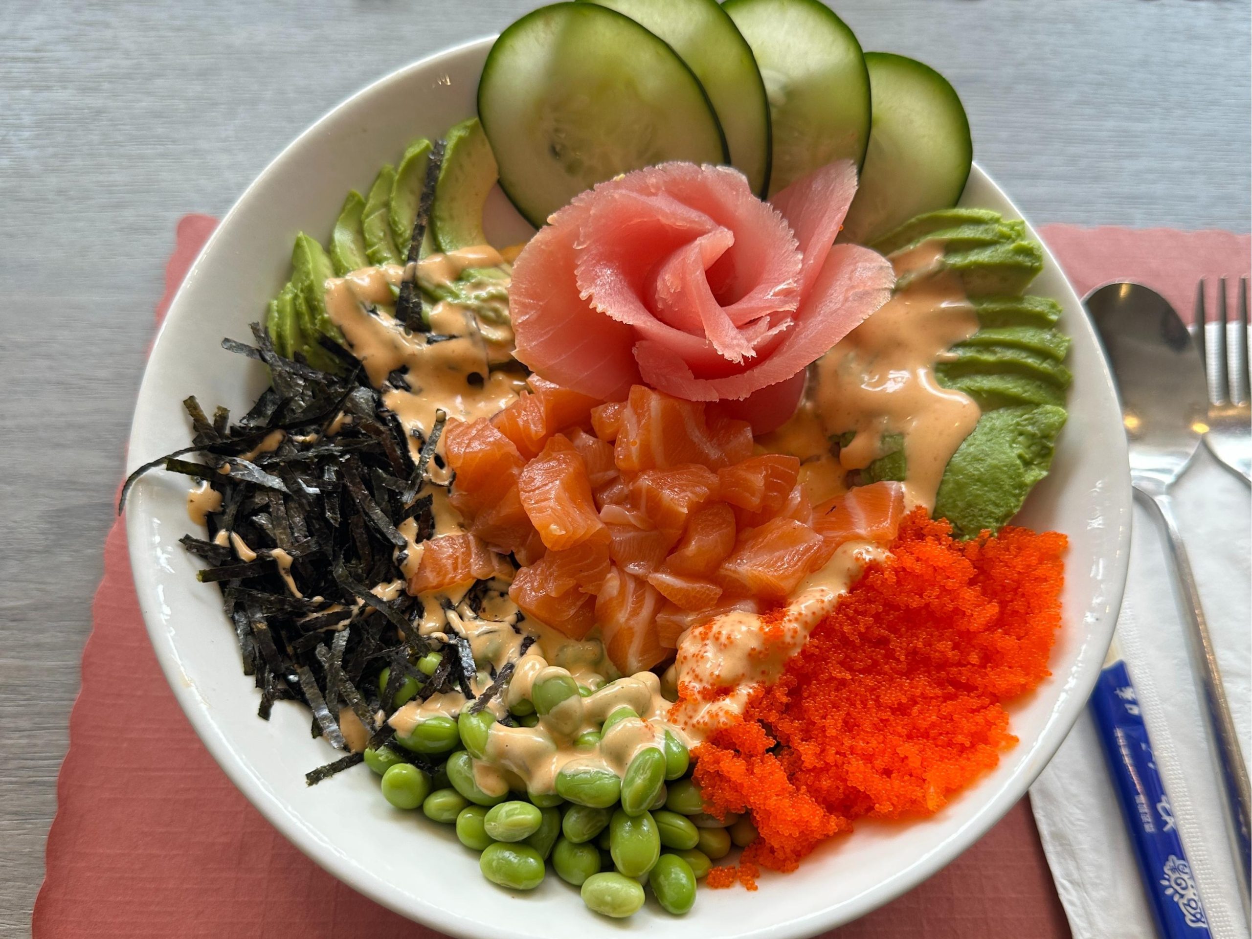 A colorful poke bowl with salmon, avocado, cucumber, seaweed, edamame, and tobiko at Tora Sushi, a Asian Fusion Restaurant in Media
