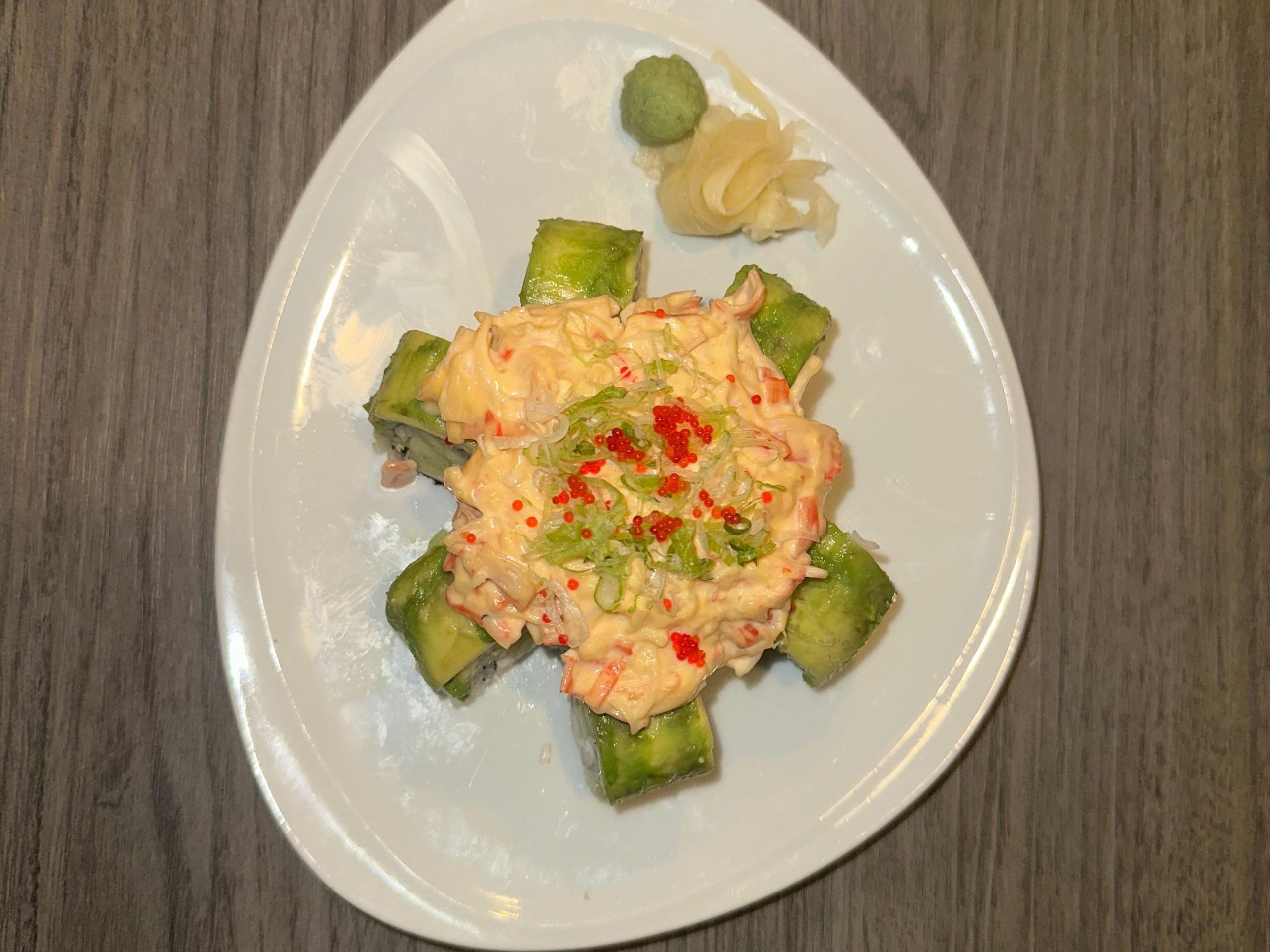 Sushi roll topped with crab salad, scallions, and tobiko on avocado at Tora Sushi, a Asian Fusion Restaurant in Media