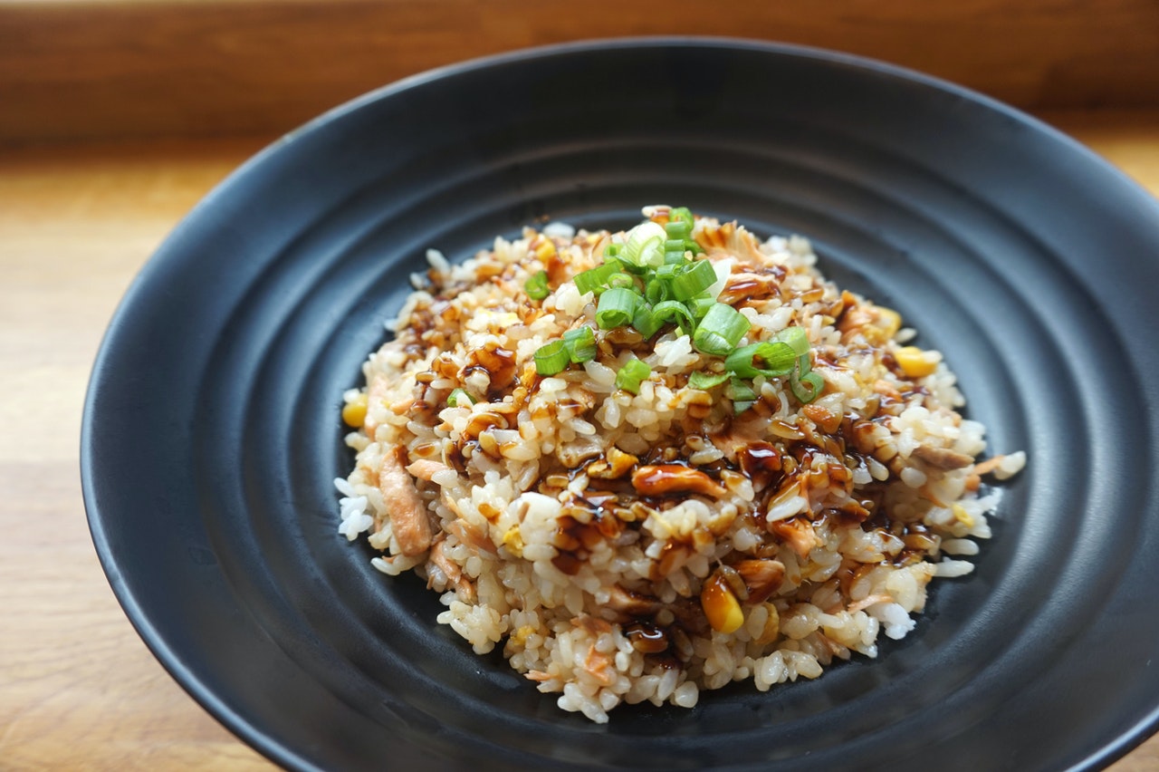 Plate of fried rice topped with soy sauce and green onions