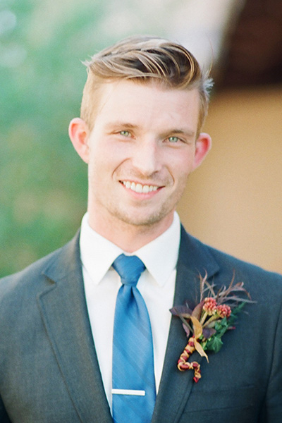 Portrait of Michael, identified as a food critic, wearing a suit with a boutonniere