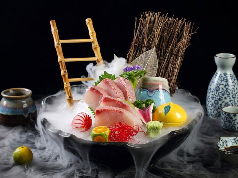 Smoky chilled sashimi platter with white fish slices, bamboo ladder garnish and decorative tableware at Toromi Sushi , a Sushi Restaurant in West Covina