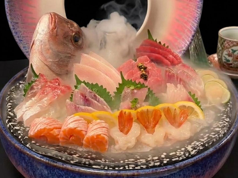 Whole fish sashimi platter loaded with assorted salmon, shrimp and raw fish slices on ice with misty dry ice smoke at Toromi Sushi , a Sushi Restaurant in West Covina