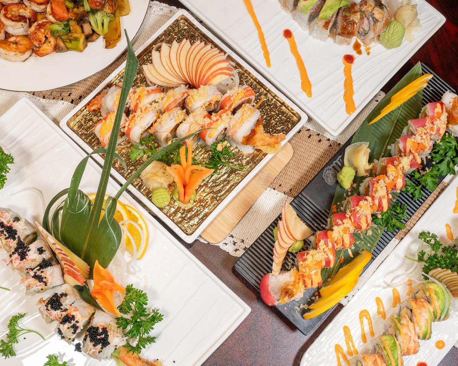 Assorted premium sushi roll platter artfully plated with fruit and fresh herb garnishes at Ubin Sushi, a Japanese restaurant in Colorado Springs