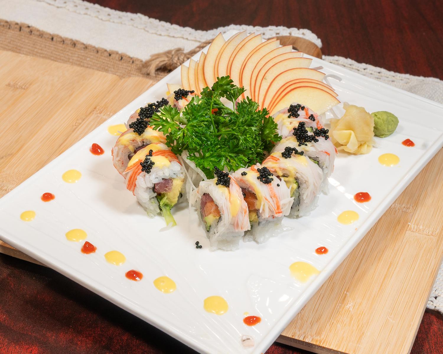 Seafood maki roll with caviar, imitation crab and decorative fruit slices on white plate at Ubin Sushi, a Japanese restaurant in Colorado Springs