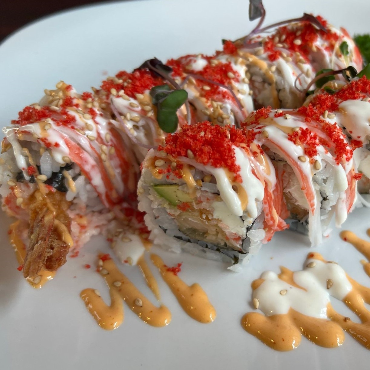 Seafood sushi roll covered with shredded crab, red tobiko and creamy spicy sauce at Umami Sushi & Chinese Cuisine, an Asian Fusion Restaurant in Minneapolis