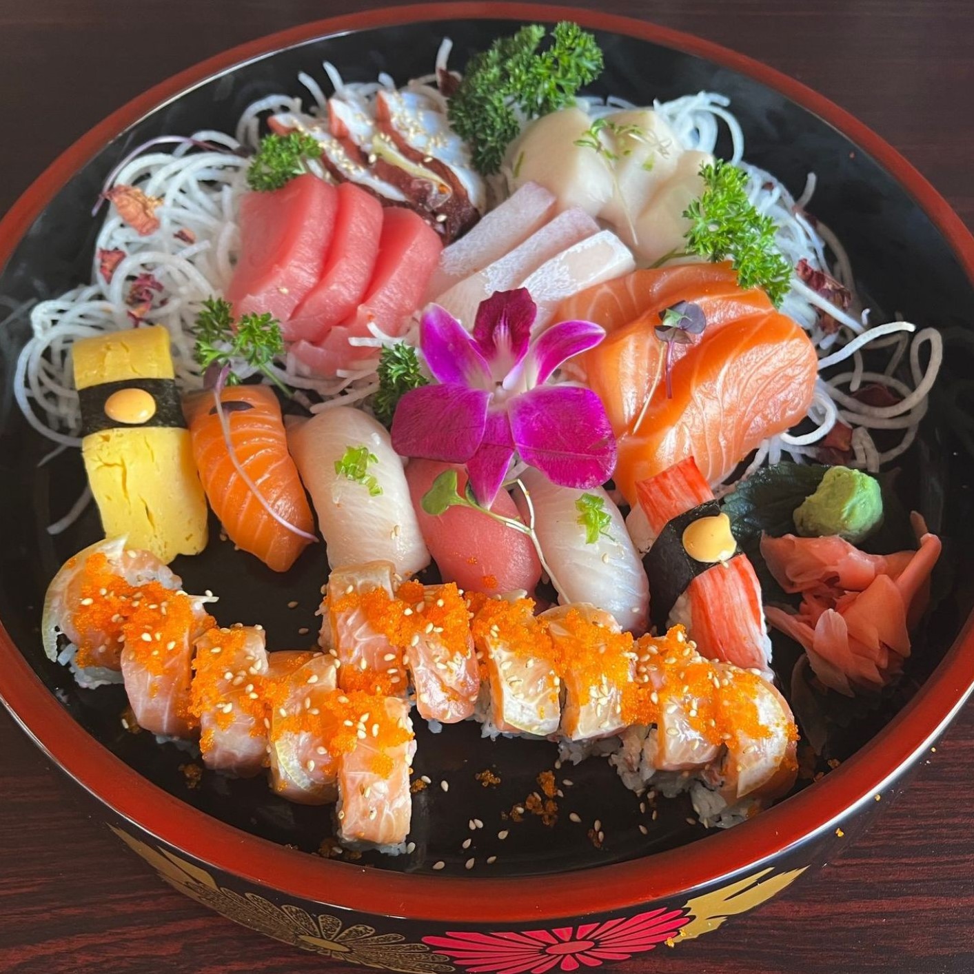 Large mixed sashimi and sushi platter garnished with purple orchid flower at Umami Sushi & Chinese Cuisine, an Asian Fusion Restaurant in Minneapolis