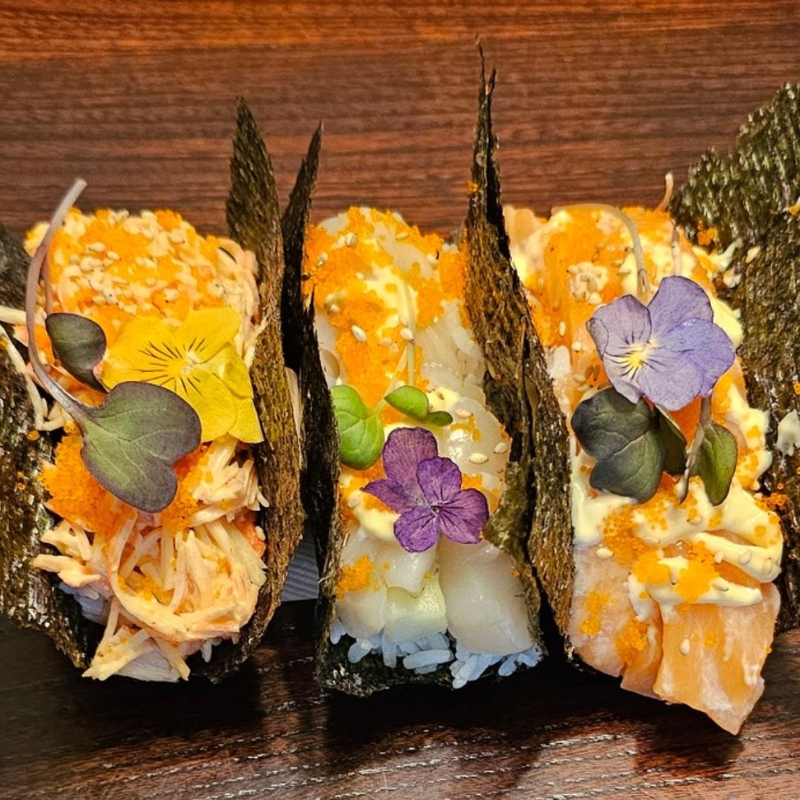 Three fancy seafood temaki garnished with edible flowers at Umami Sushi & Chinese Cuisine, an Asian Fusion Restaurant in Minneapolis