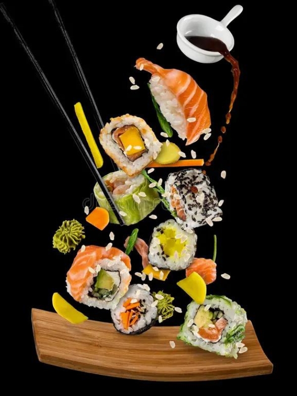 Assorted sushi pieces flying with soy sauce and sesame seeds at Umami Sushi Pdx Food Cart, a Japanese Restaurant in Portland