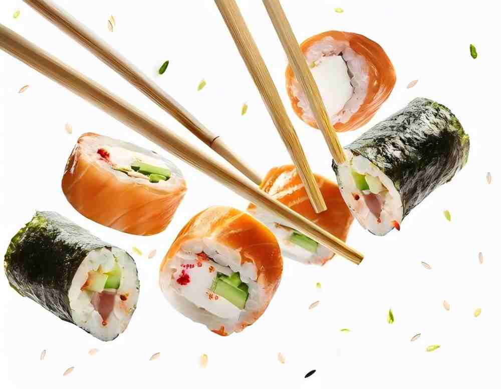 Mixed sushi rolls flying with chopsticks and seeds at Umami Sushi Pdx Food Cart, a Japanese Restaurant in Portland