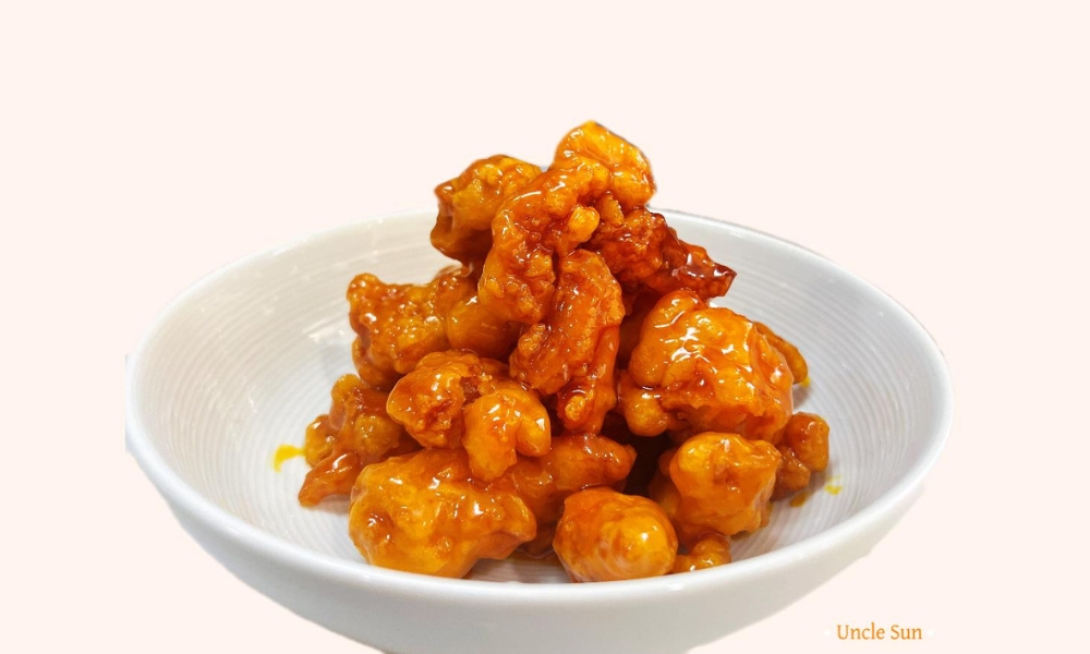 Crispy orange chicken pieces in a white bowl at Uncle Sun, a Chinese Restaurant in Eugene