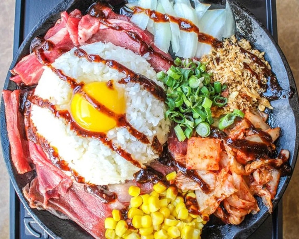 Sizzling bacon rice with egg, kimchi, and corn at Uniboil Phresh Teas Co, a Hot Pot Restaurant in Goleta.