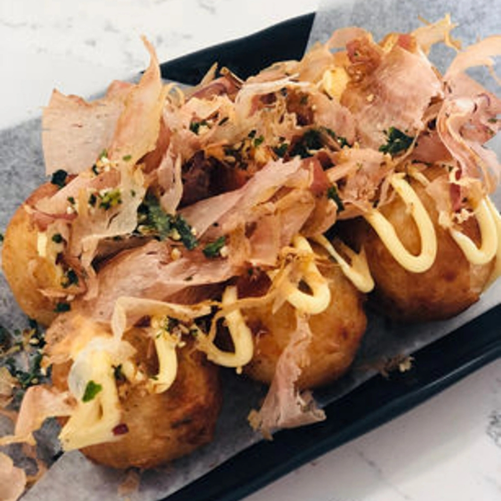 Golden takoyaki with bonito flakes and mayo at Uniboil Phresh Teas Co, a Hot Pot Restaurant in Goleta.