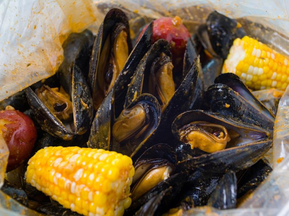Seasoned black mussels with corn and potato at Utica Crab & Boil, a Seafood Restaurant in Utica