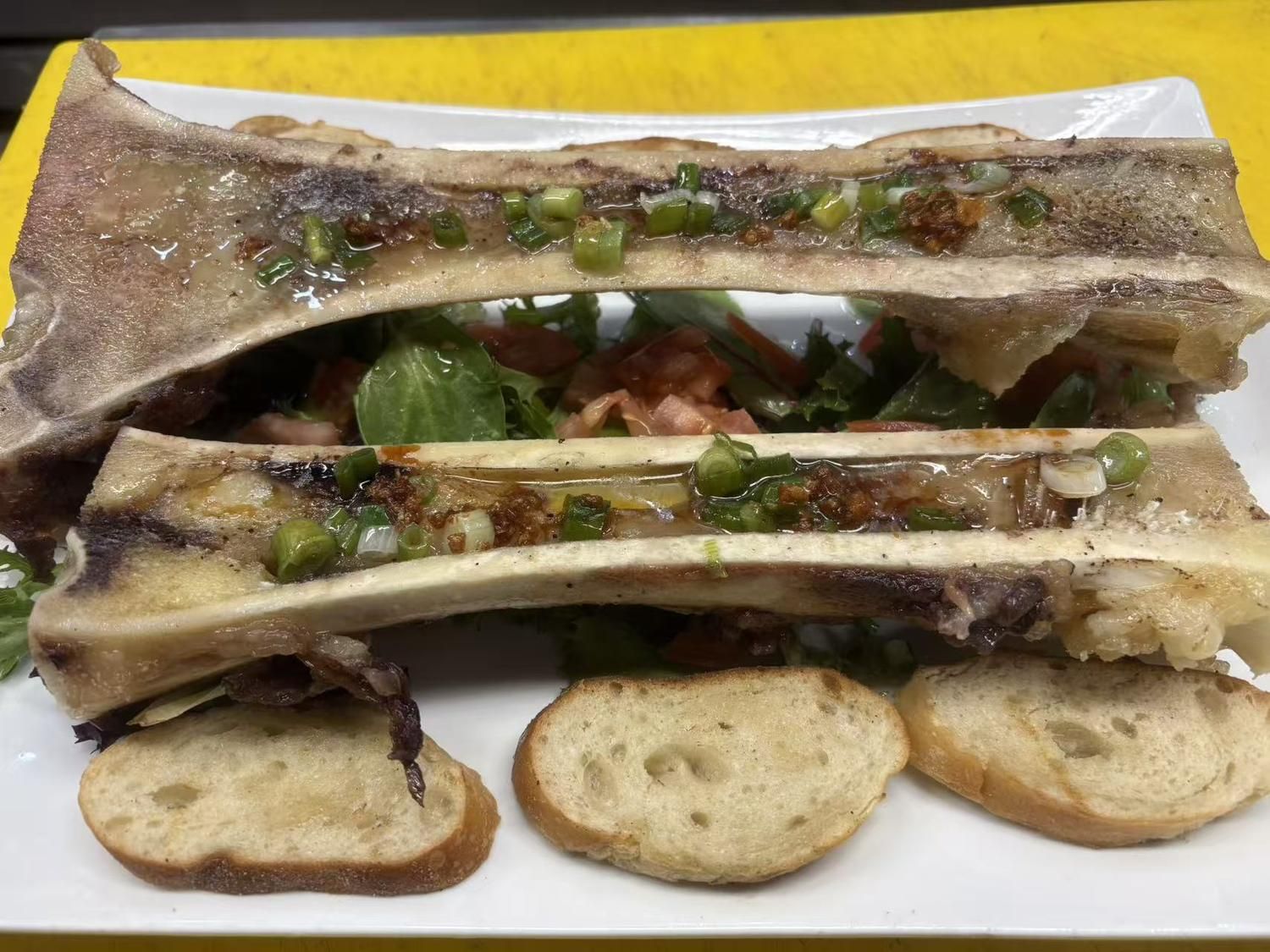 Roasted bone marrow with bread slices and scallions at Viet Quan Vietnamese Noodle House, a Vietnamese Restaurant in San Francisco