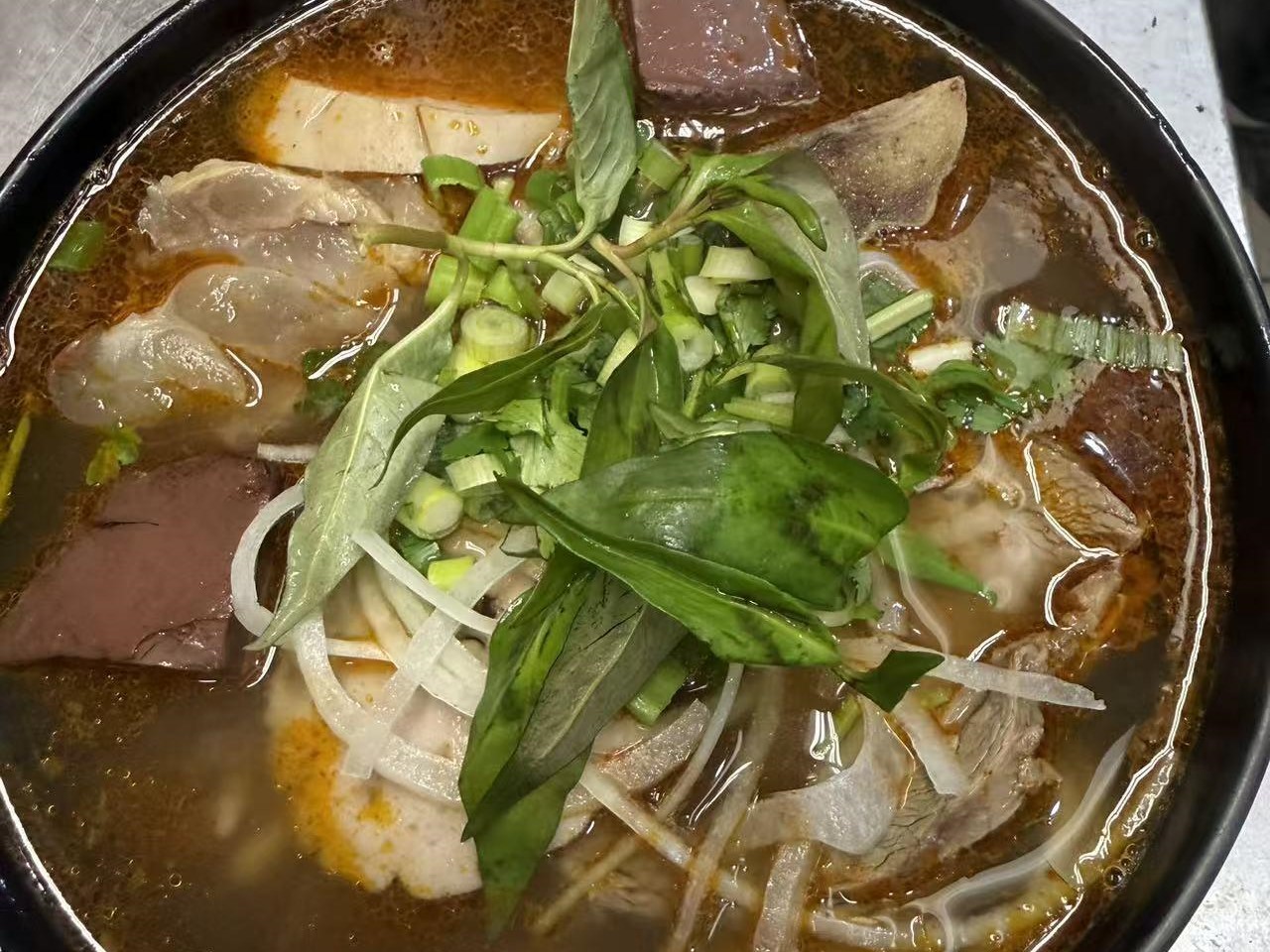 Spicy beef noodle soup with herbs and blood cake at Viet Quan Vietnamese Noodle House, a Vietnamese Restaurant in San Francisco