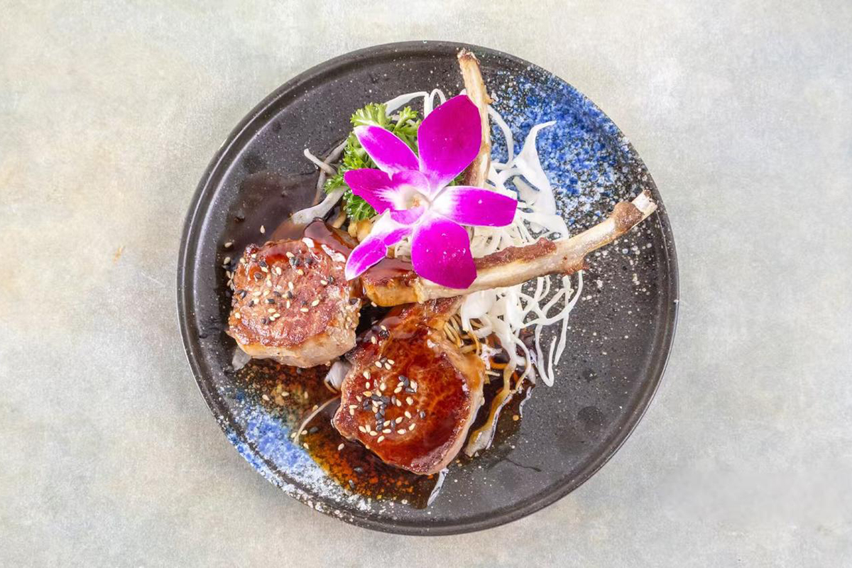 Glazed lamb chops with sesame and orchid garnish at Wabi Wok & Ramen, an Asian Restaurant in Milford