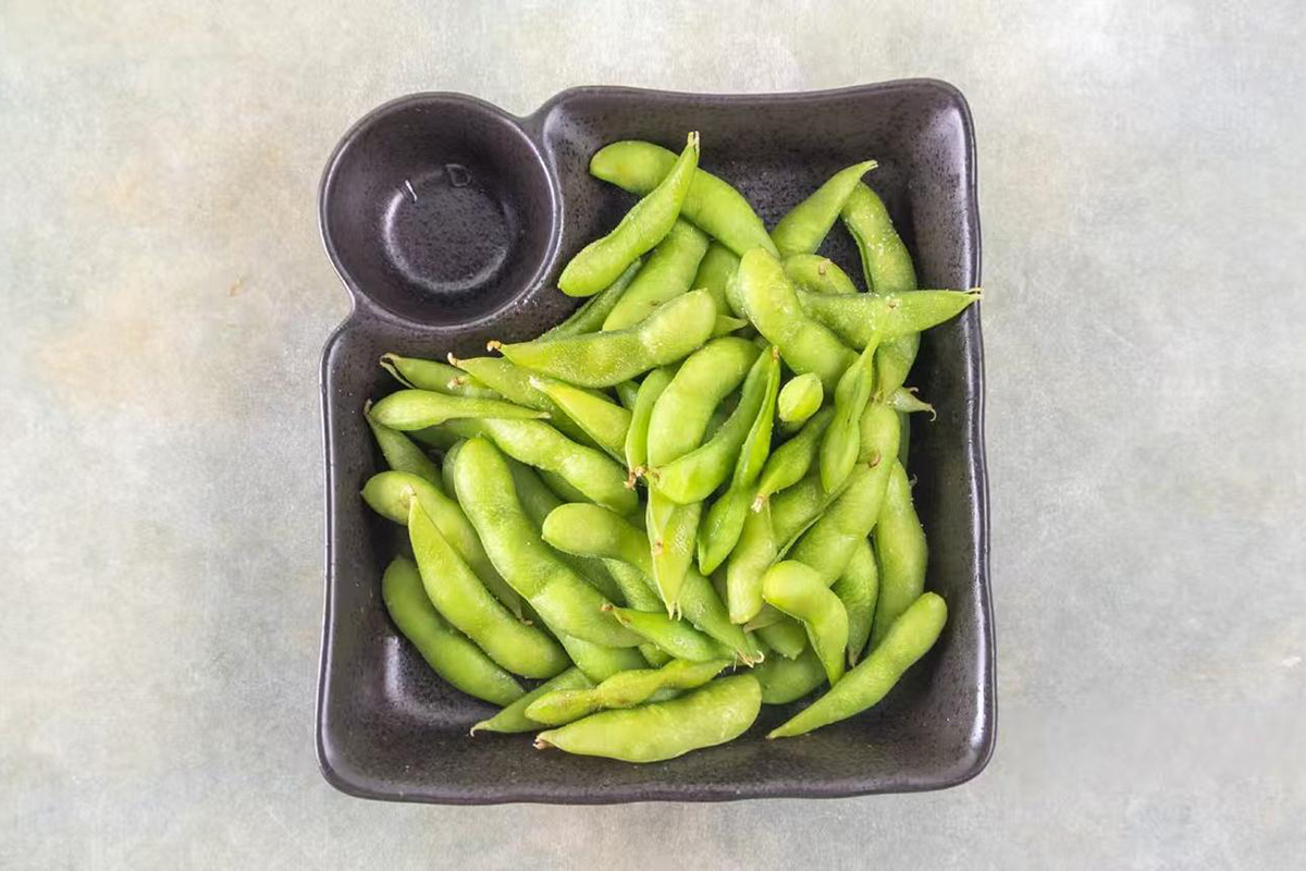 Steamed edamame served in a black dish at Wabi Wok & Ramen, an Asian Restaurant in Milford