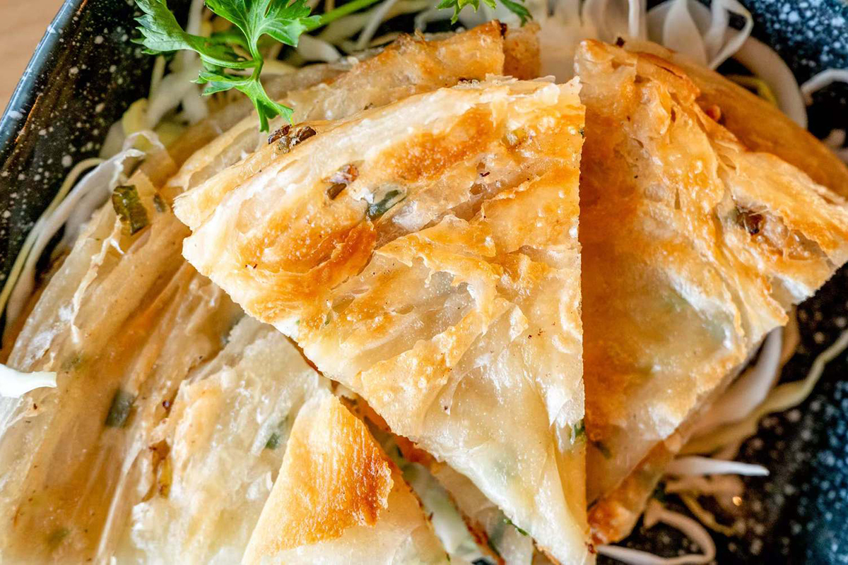 Crispy scallion pancakes cut into golden wedges at Wabi Wok & Ramen, an Asian Restaurant in Milford