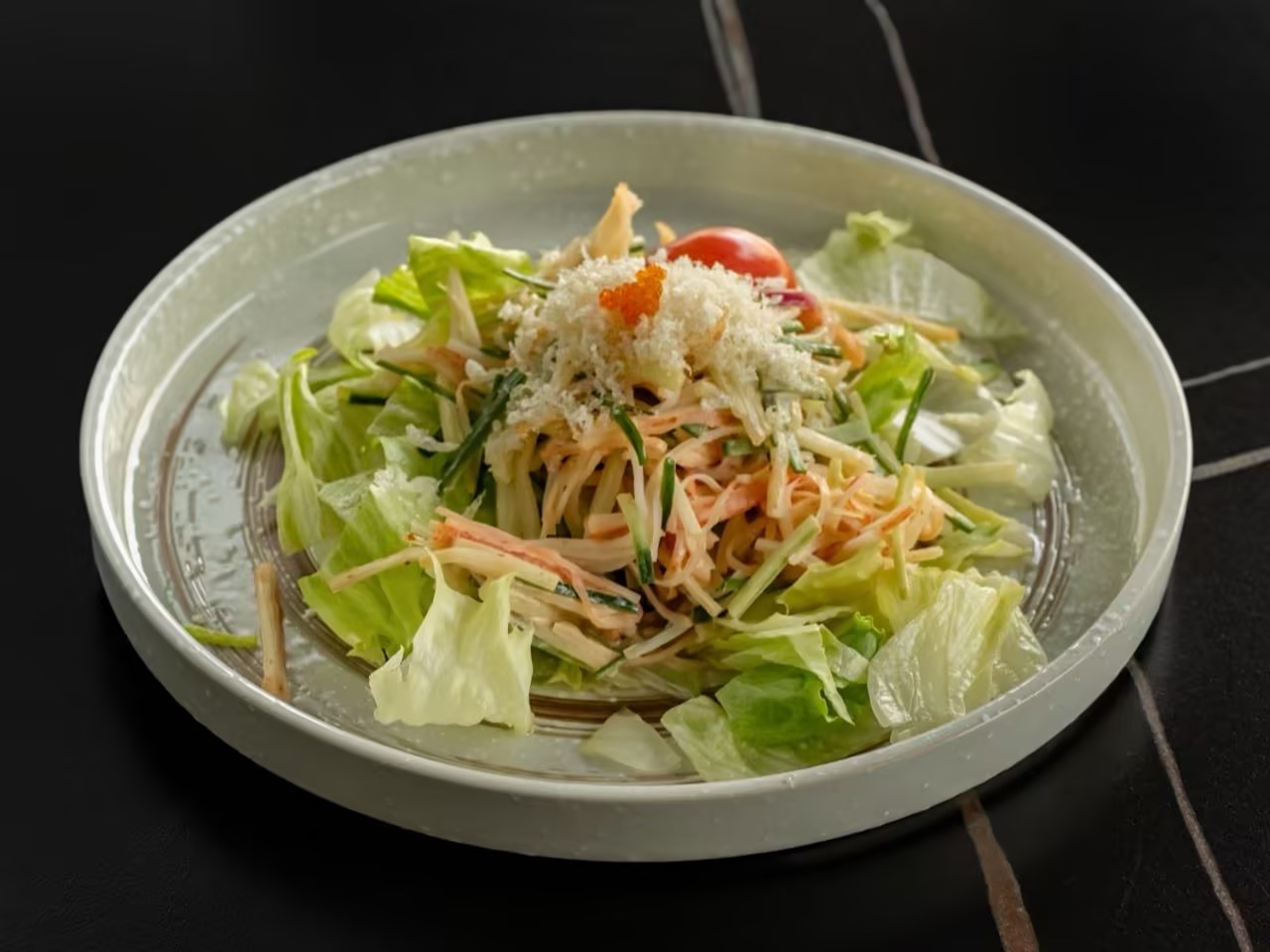 Fresh salad with shredded crab, lettuce, cucumber, tomato, and crispy toppings