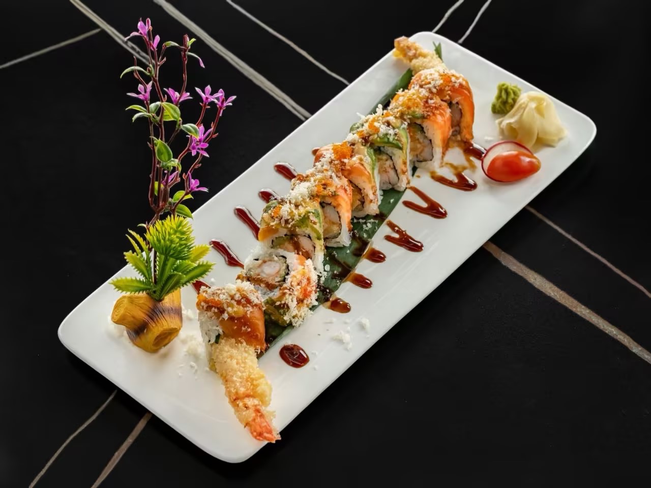 Specialty sushi roll with salmon, avocado, crispy toppings, shrimp tempura, and savory sauce