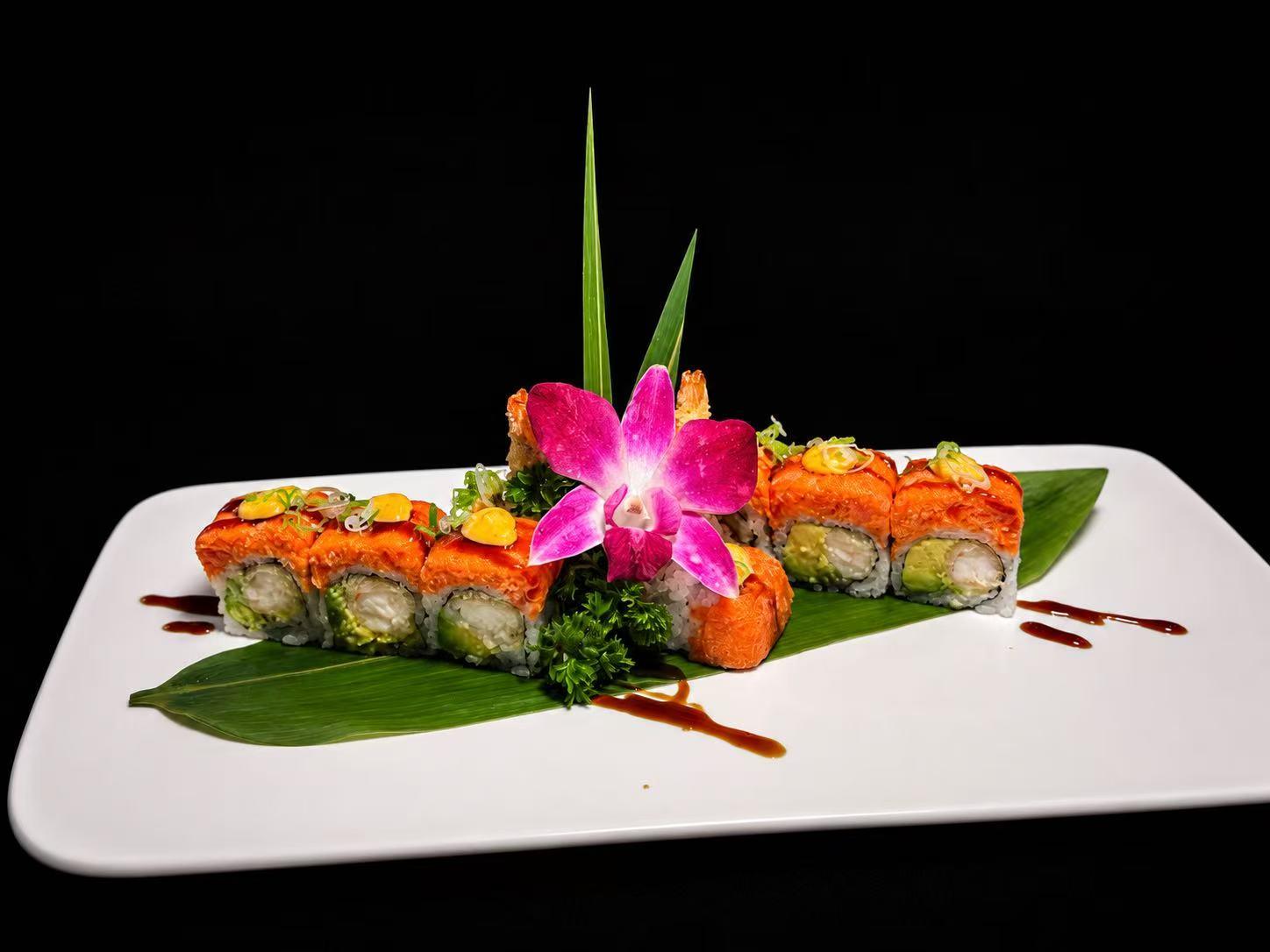Salmon sushi roll topped with sauce and garnished with an orchid at Wasu Sushi Ramen, a Sushi restaurant in Bedminster