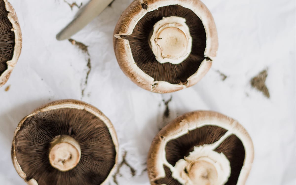 Portobello mushrooms on a white stone - patterned background