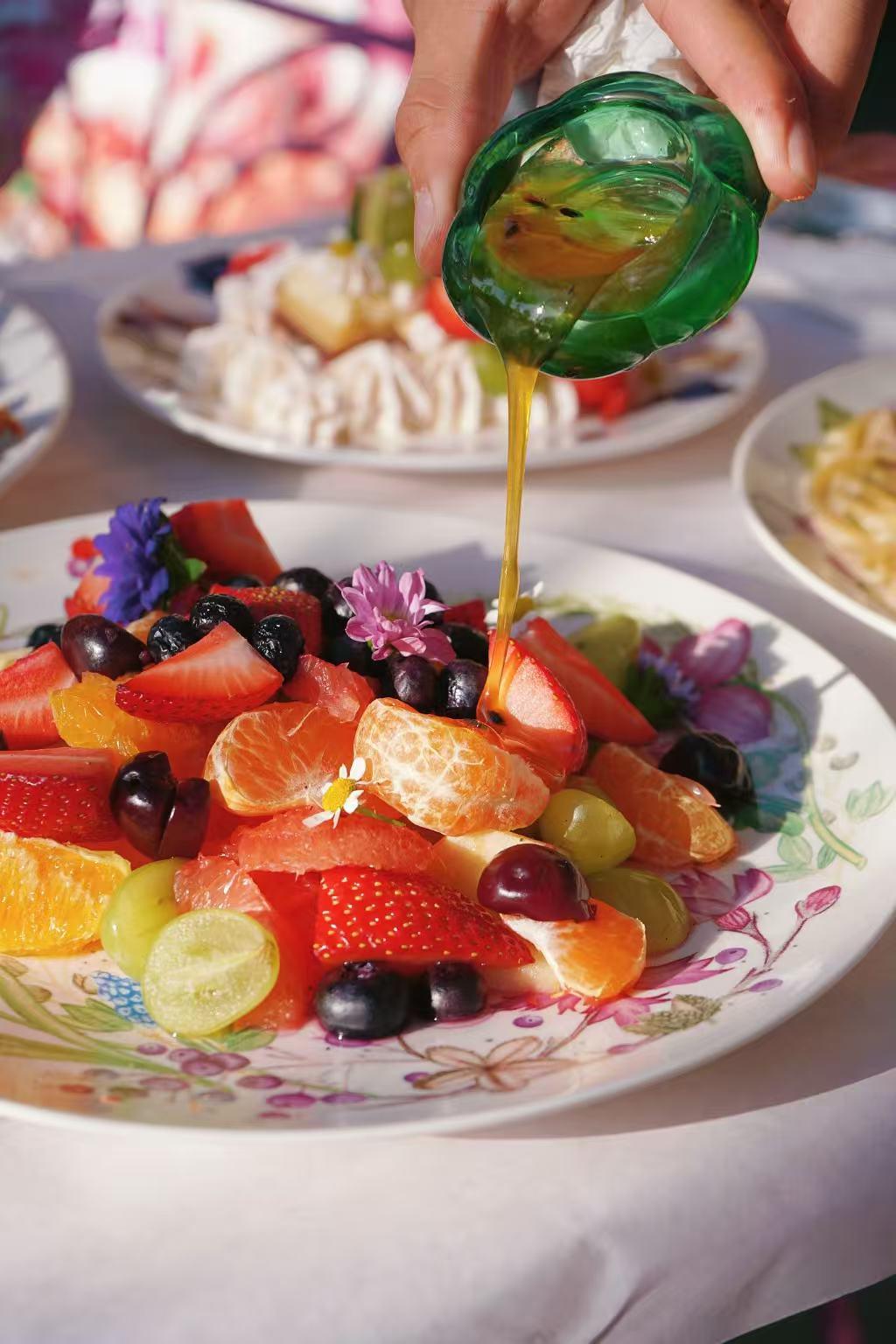 Jin-Foodie-New-American-Restaurant-Mixed-Fruit-Platter-with-Honey-West-Covina Mixed fruit platter with honey being drizzled at Jin Foodie, a New American Restaurant in West Covina