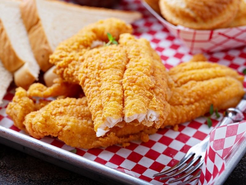 Crispy fried chicken strips served with toast on checkered paper at Which Wings, Fast Food Restaurant in Fort Worth
