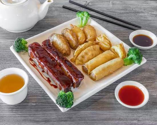 Plate of BBQ ribs, fried appetizers, and dipping sauces at Wild Ginger Asian Bistro, a Asian restaurant in Gilbert