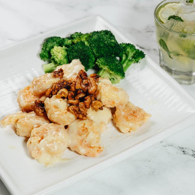 Honey walnut shrimp with broccoli on a white square plate