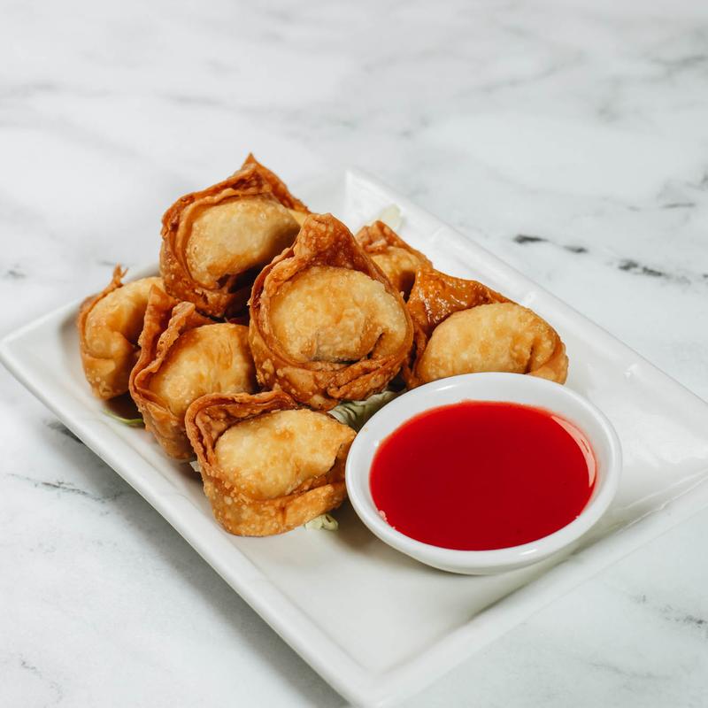 Fried wontons with sweet and sour sauce on a white plate