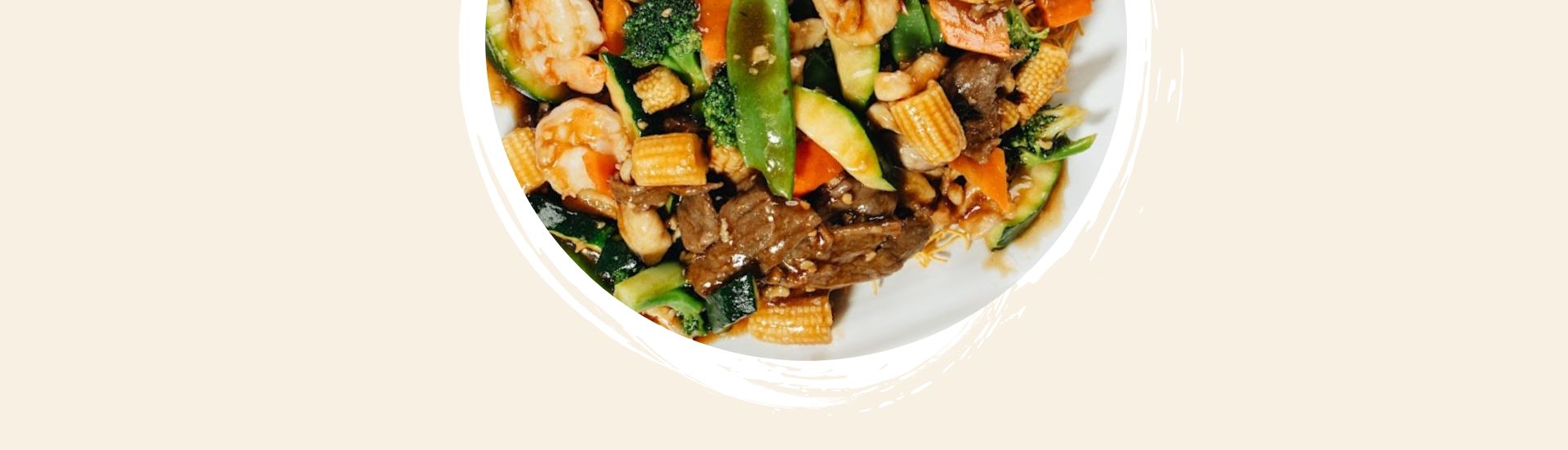 `Colorful Asian stir-fry with shrimp, beef, and vegetables in a white bowl`