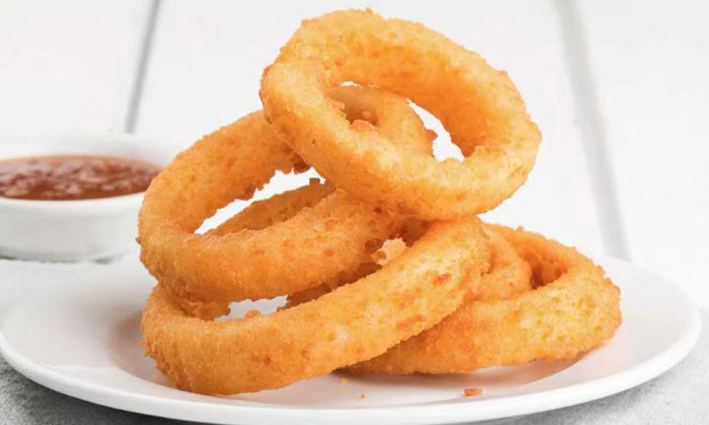 Crispy fried onion rings with dipping sauce on white plate