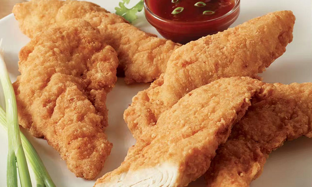 Breaded chicken tenders with sweet chili sauce and green onion garnish