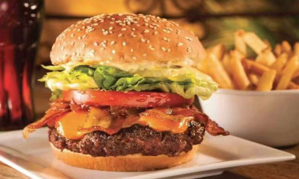 Bacon cheeseburger with lettuce, tomato, and side of French fries