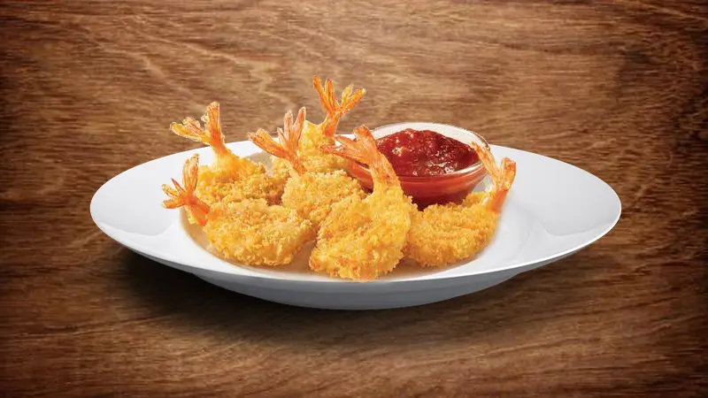 Crispy butterfly shrimp with a side of dipping sauce at Wings & Seafood, a Seafood Restaurant in Ridgewood