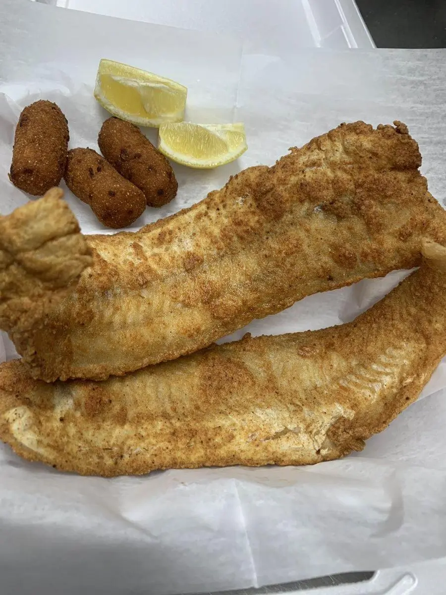 Crispy fried fish fillets with hush puppies and lemon wedges at Wings & Seafood, a Seafood Restaurant in Ridgewood