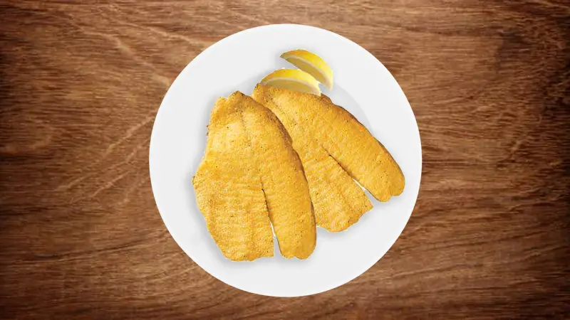 Fried tilapia fillets served with lemon slices at Wings & Seafood, a Seafood Restaurant in Ridgewood