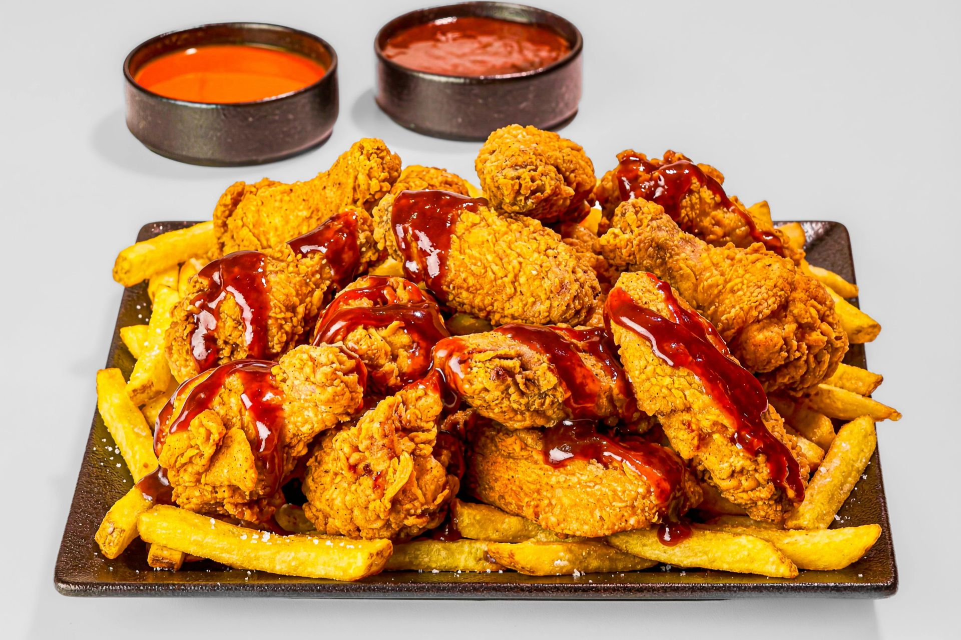 Crispy fried chicken wings and fries with BBQ sauce and dips at Wing Star, a American fusion restaurant in Amsterdam
