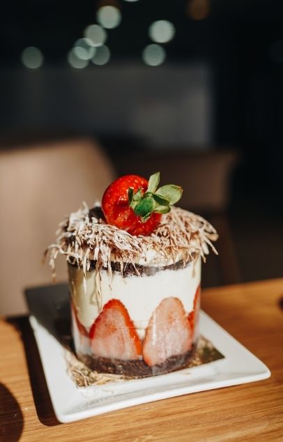 Mini strawberry layered cake with chocolate crust and coconut topping at Wing Star, a American fusion restaurant in Amsterdam