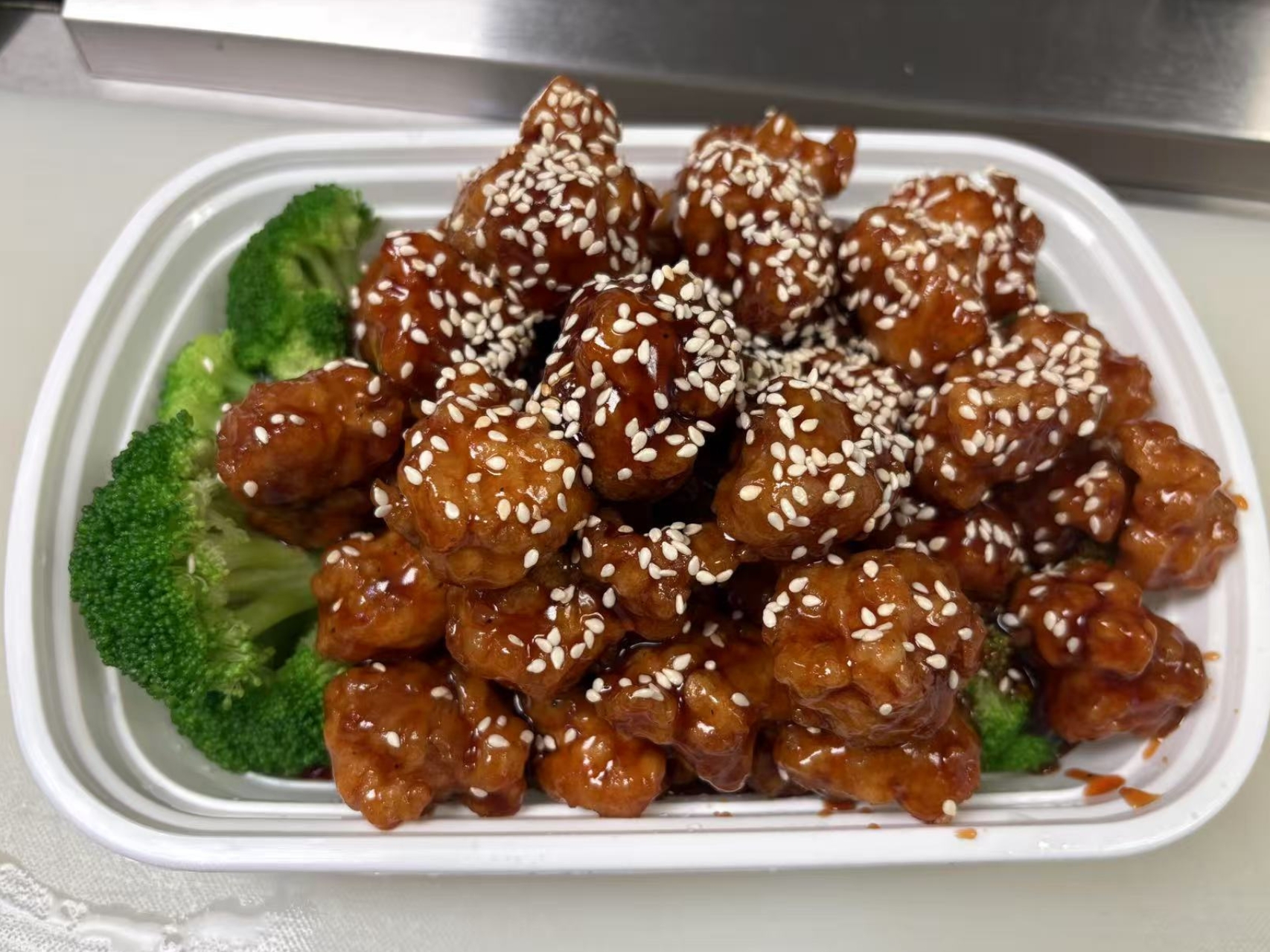 Crispy chicken with sesame seeds and broccoli.