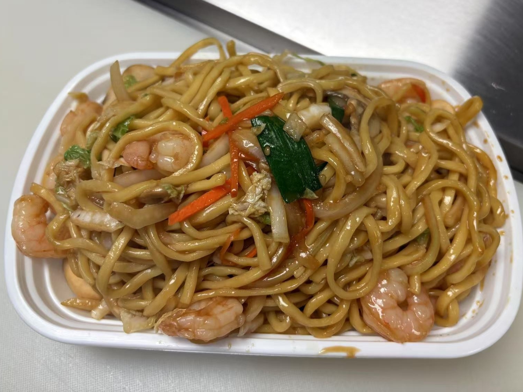 Lo mein noodles with shrimp and veggies, stir - fried.