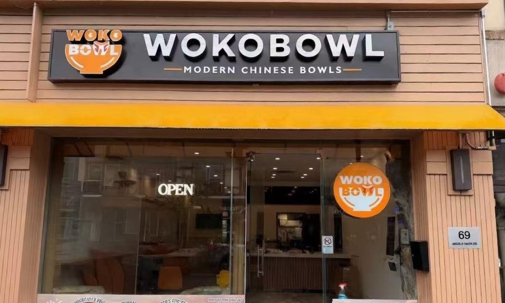 Front entrance of WOKOBOWL store with wooden siding and food poster windows at WOKOBOWL, a Chinese Restaurant in Glen Cove