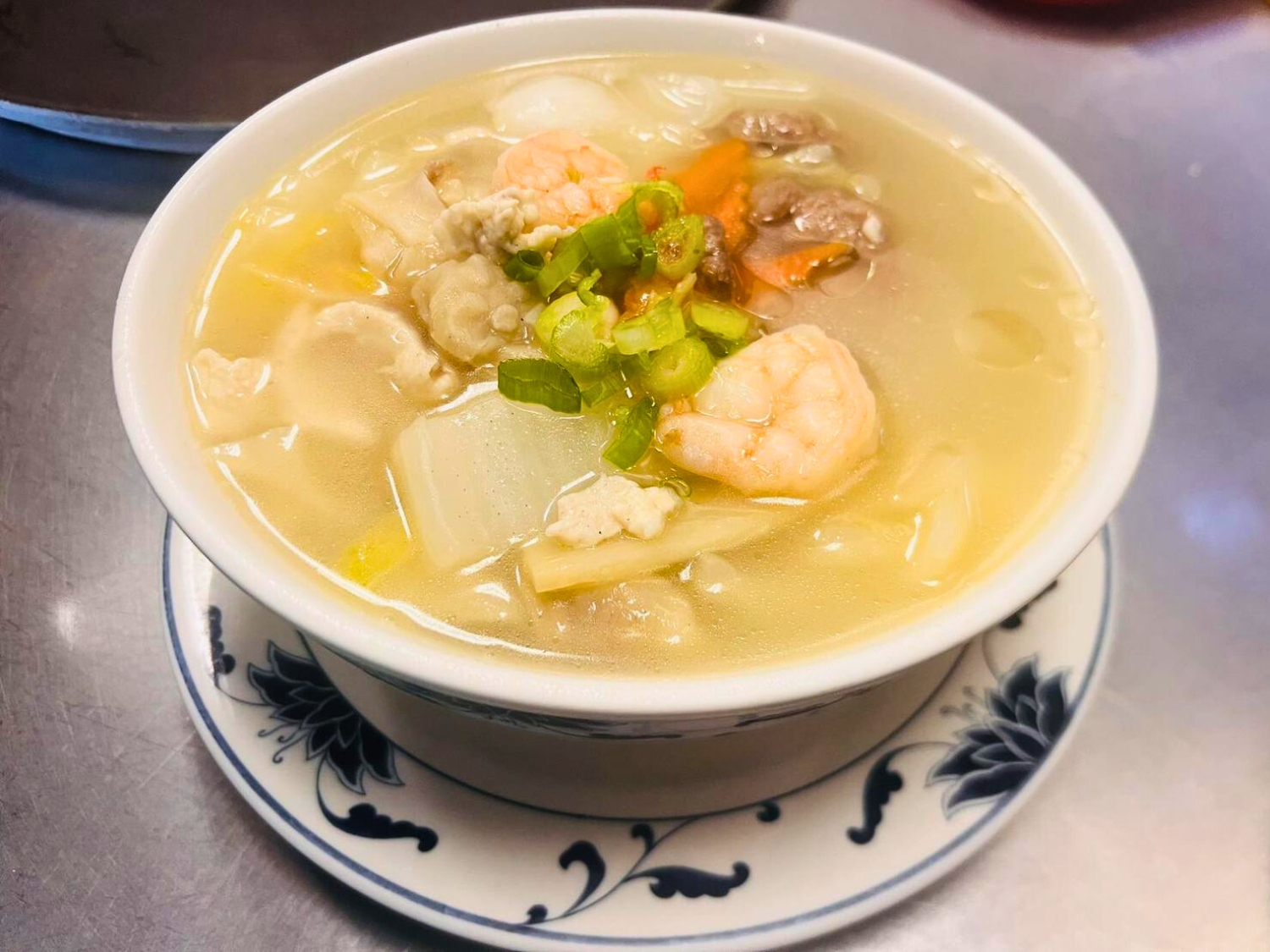 A bowl of wonton soup with shrimp, meat, and veggies, topped with green onions at Wok's Cookin', a Chinese Restaurant in Castaic