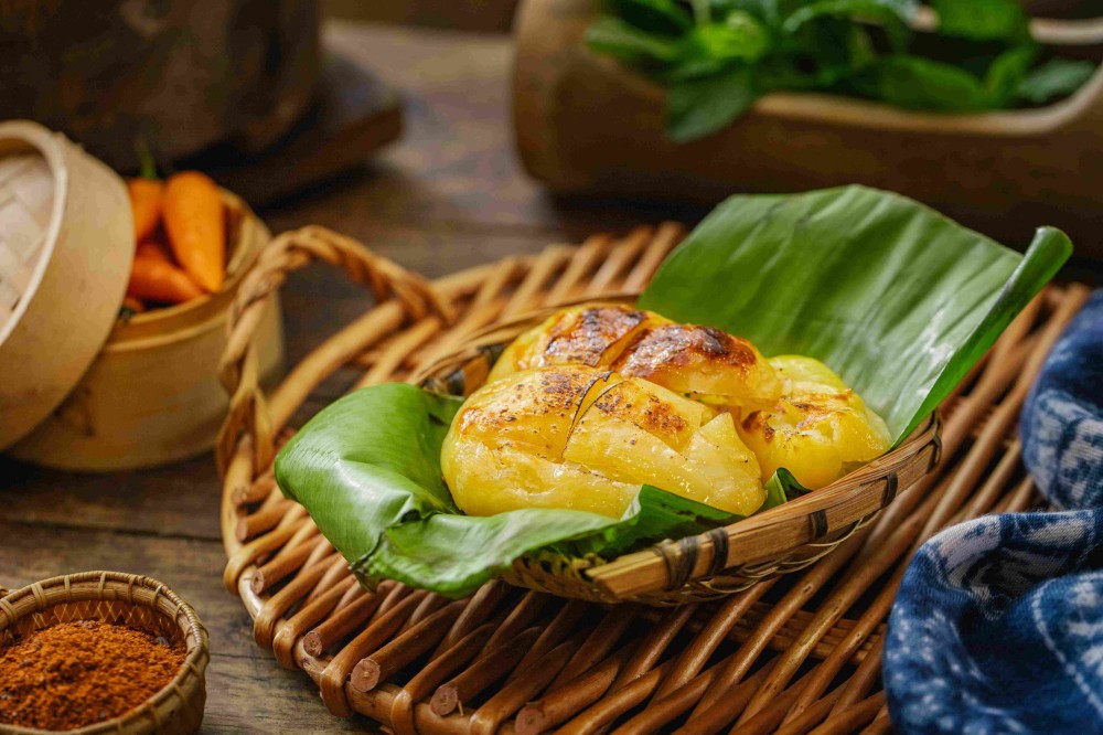 Charred roasted potatoes wrapped in banana leaf at Xiaozhan Rice Noodle, a Chinese Noodle Restaurant in Flushing