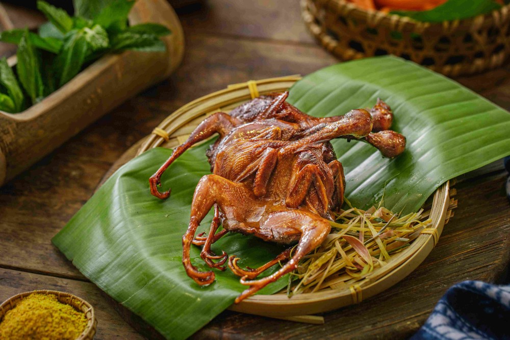 Crispy roasted quail on banana leaf with spice powder at Xiaozhan Rice Noodle, a Chinese Noodle Restaurant in Flushing