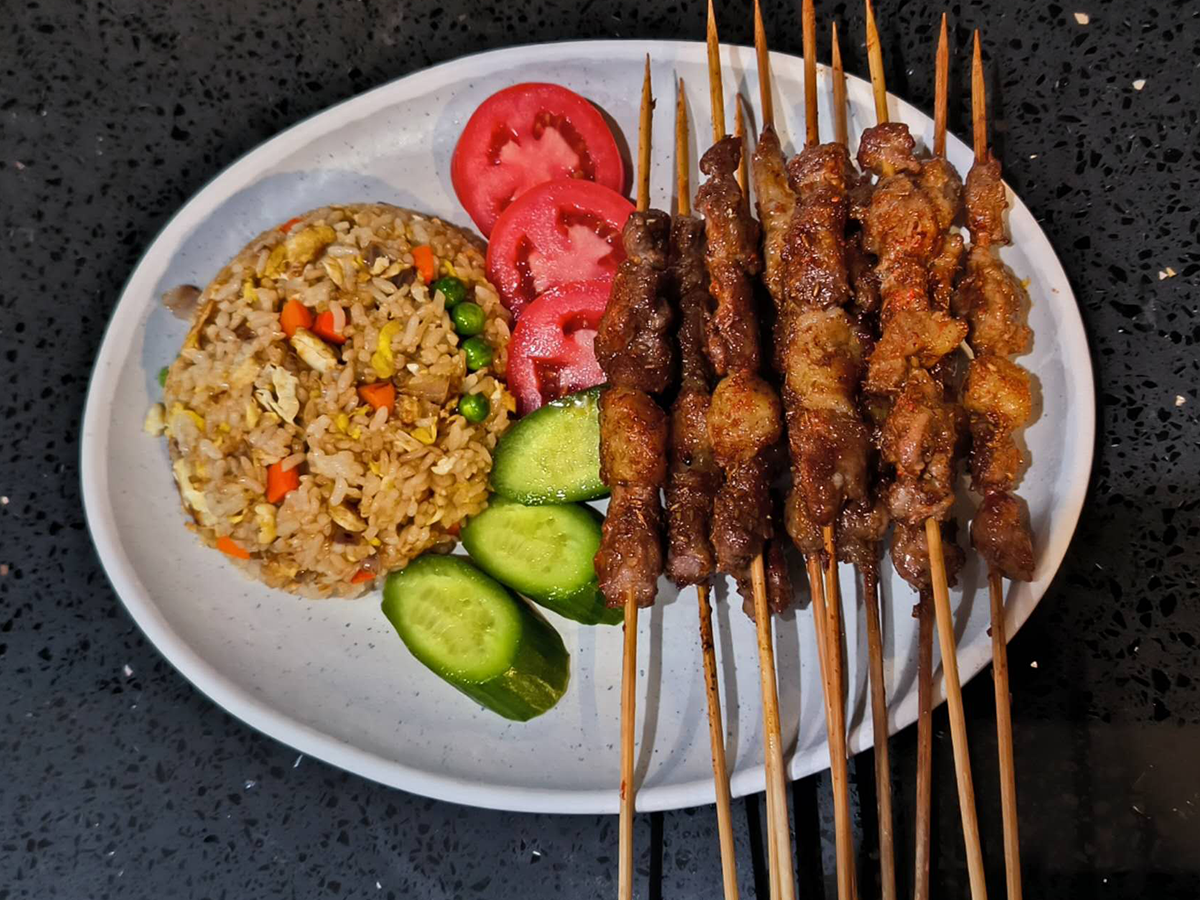 Meat skewers with fried rice, veggies at Xin Jiang BBQ, a Chinese Restaurant in Houston