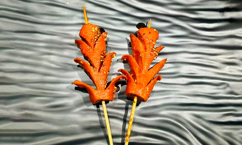 Crispy flower-cut grilled sausage skewers at Yami Bowl, a Asian Fusion Restauran in San Jose