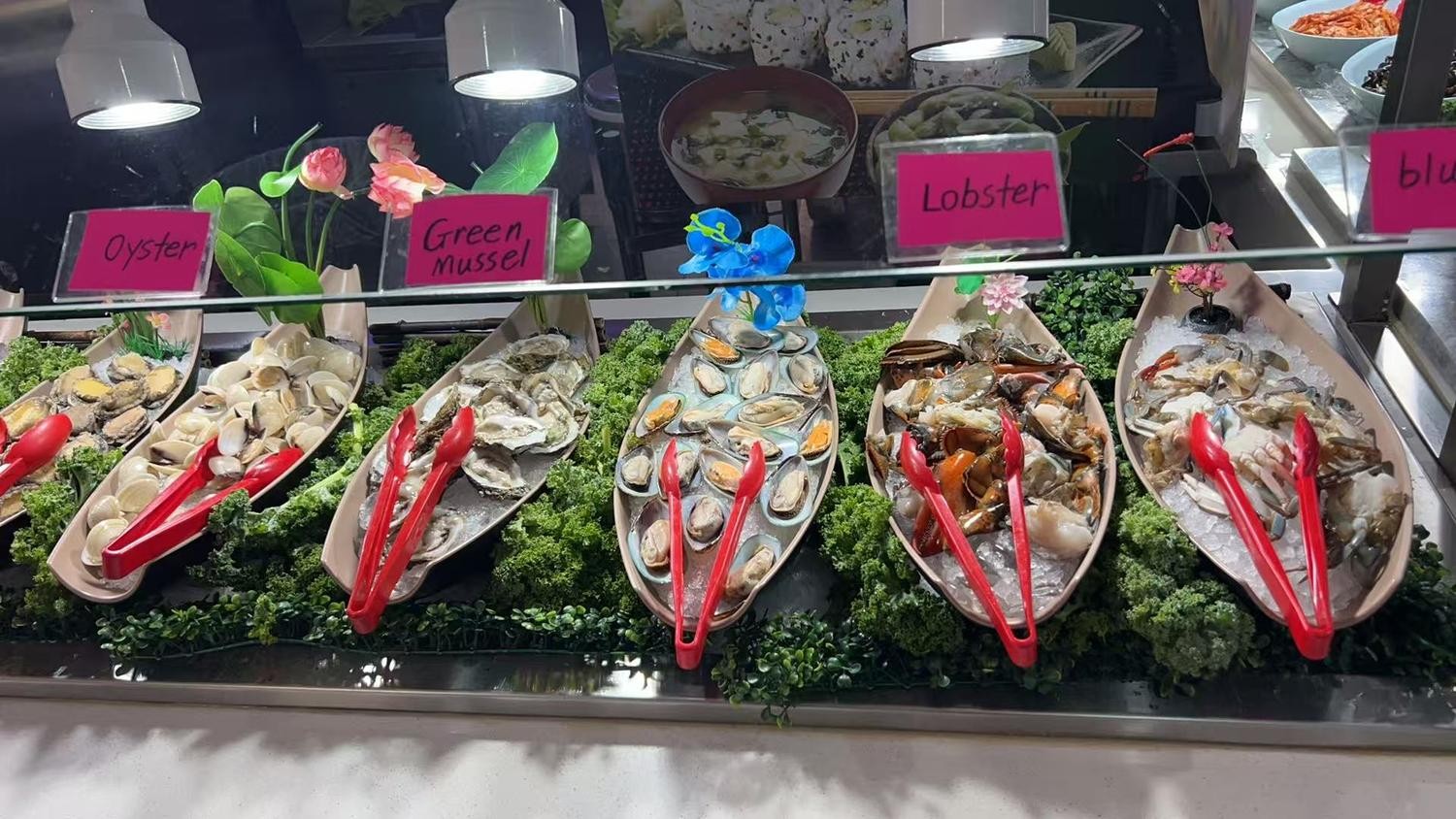 Boat-shaped trays of fresh oysters, mussels and lobster on ice at YC Seafood Hot Pot, a Hot Pot Restaurant in Virginia Beach
