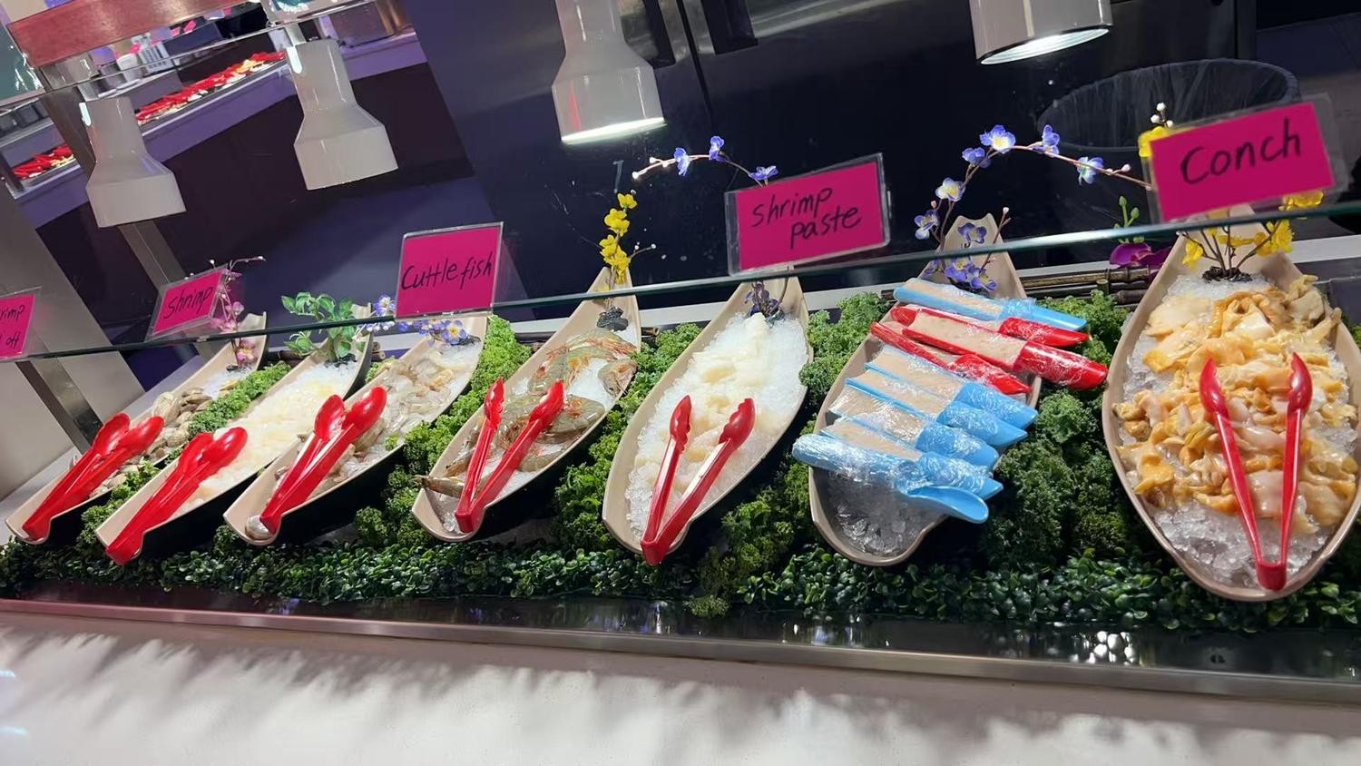 Ice-filled boat trays with cuttlefish, shrimp and conch raw seafood slices at YC Seafood Hot Pot, a Hot Pot Restaurant in Virginia Beach